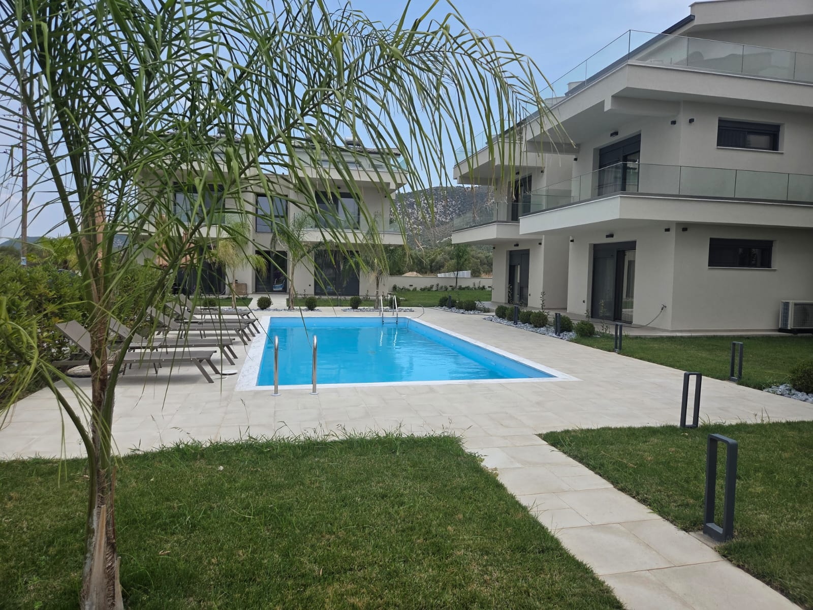 Piscină cu palmieri și apartamente moderne