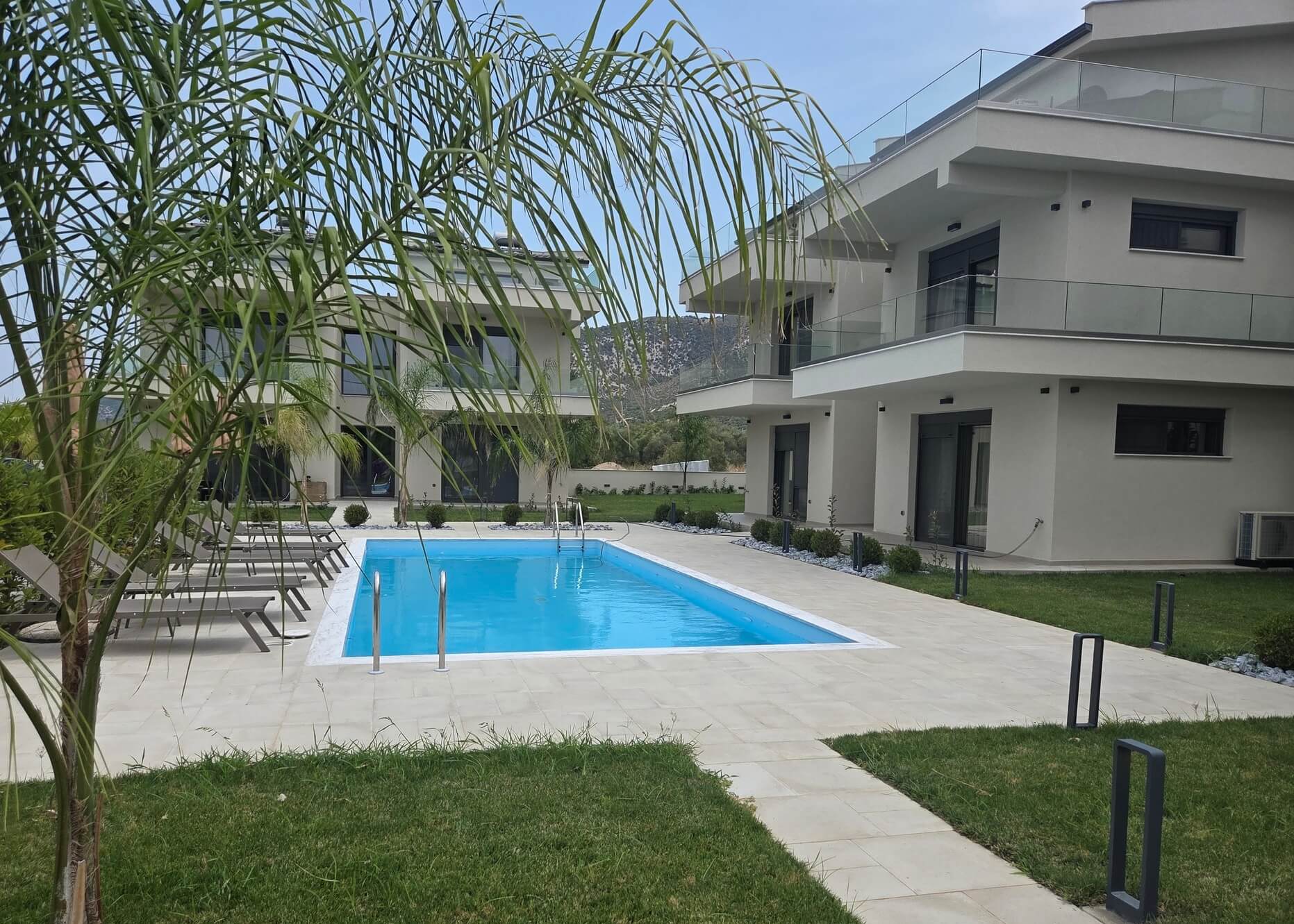 Vedere la piscină din zona de iarbă